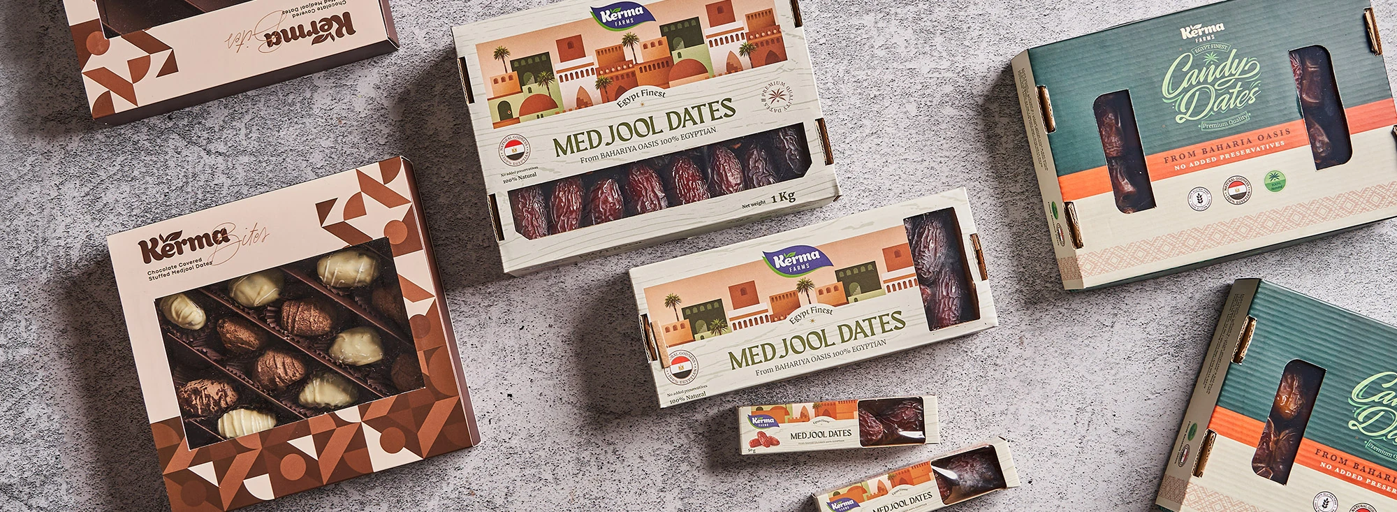Assorted Kerma Farms Medjool and candy date boxes arranged on a textured surface
